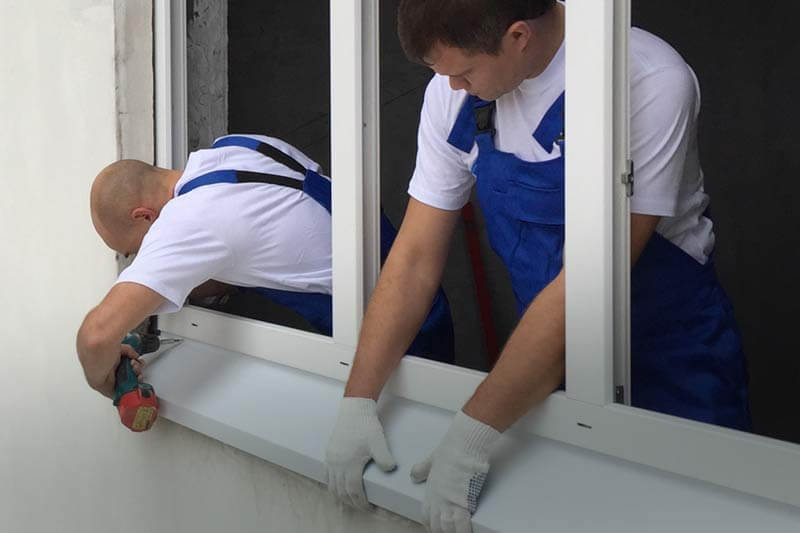 Установка окон ПВХ Монтажники устанавливают раму ПВХ окна